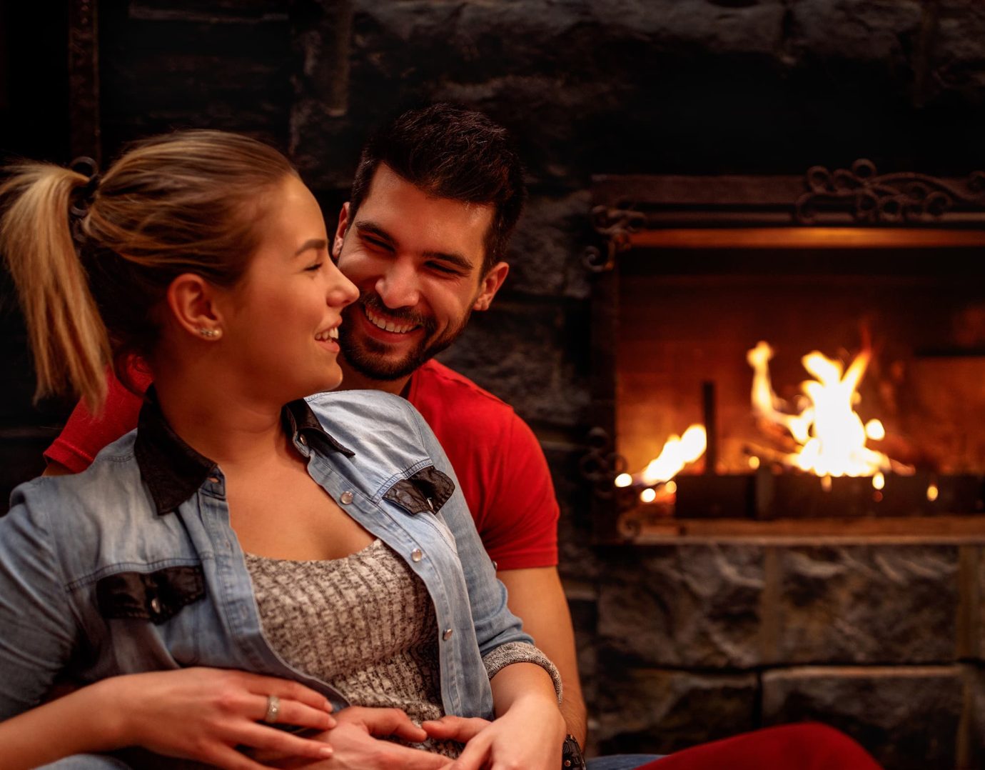 Couple by fireplace at romantic Poconos resort with restaurant