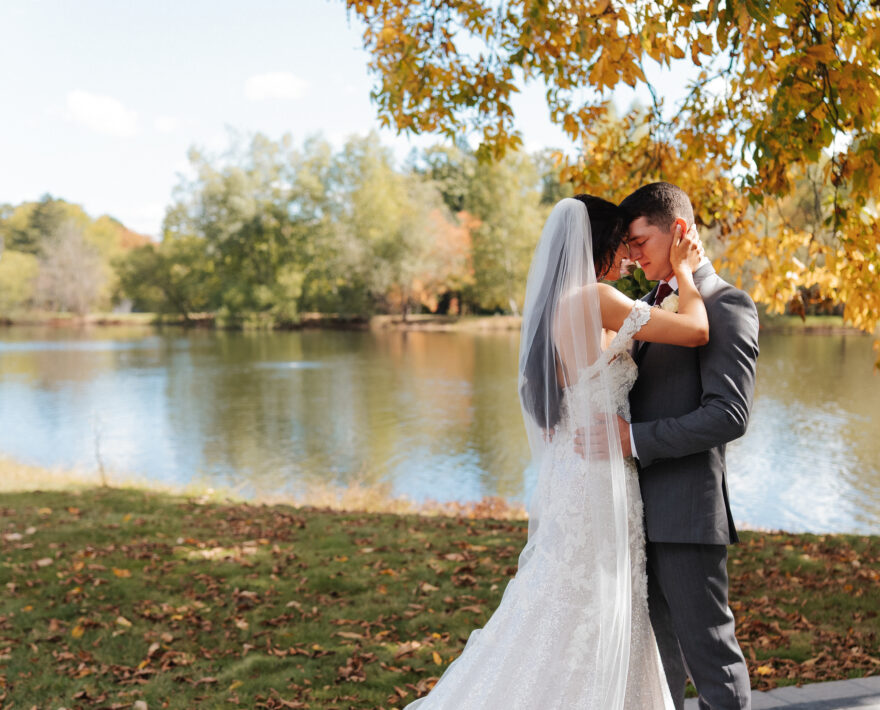 Wedding couple with arbor and lake in the background at Poconos wedding venue