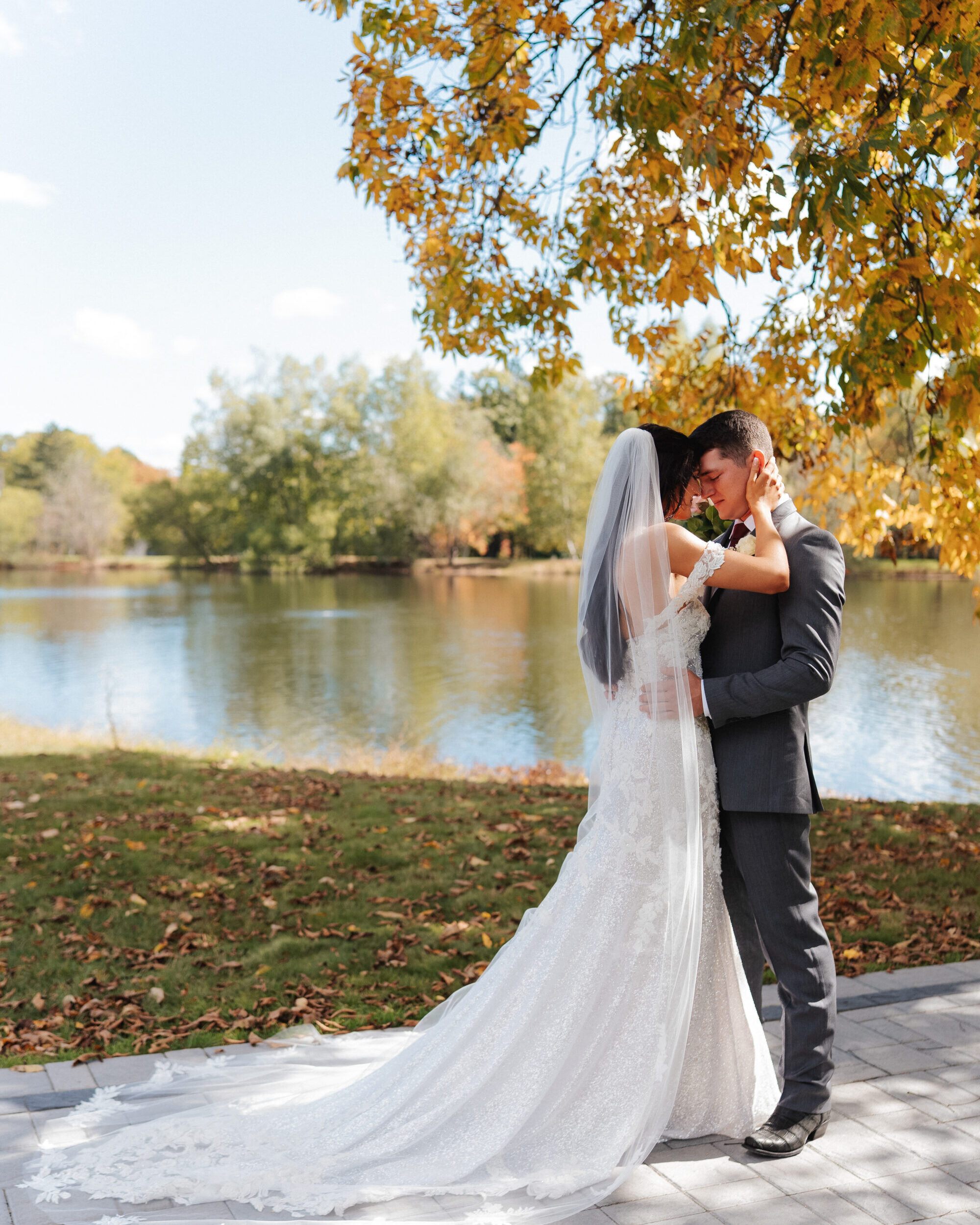 Wedding couple with arbor and lake in the background at Poconos wedding venue