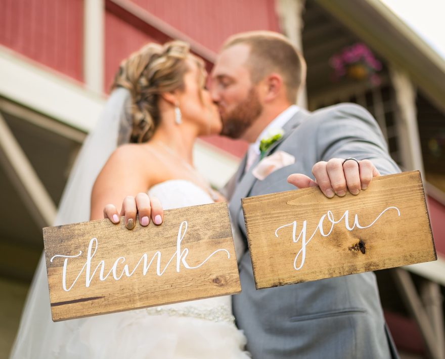 wedding couple holding thank you sign at Memorytown wedding venue